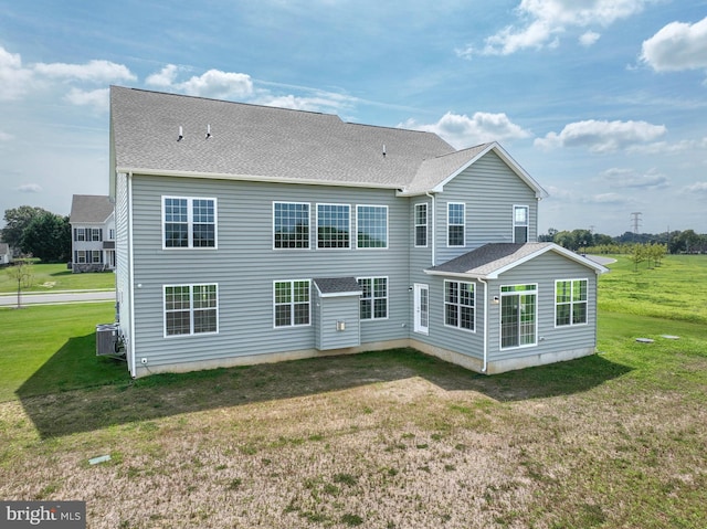 rear view of house with a lawn and central air condition unit