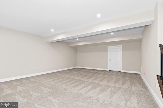 carpeted spare room featuring beamed ceiling