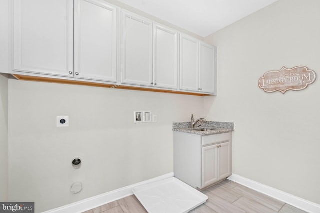 laundry area with hookup for a gas dryer, hookup for a washing machine, hookup for an electric dryer, cabinets, and sink