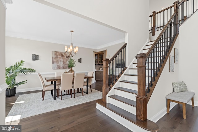 dining room with a notable chandelier, ornamental molding, and dark hardwood / wood-style floors