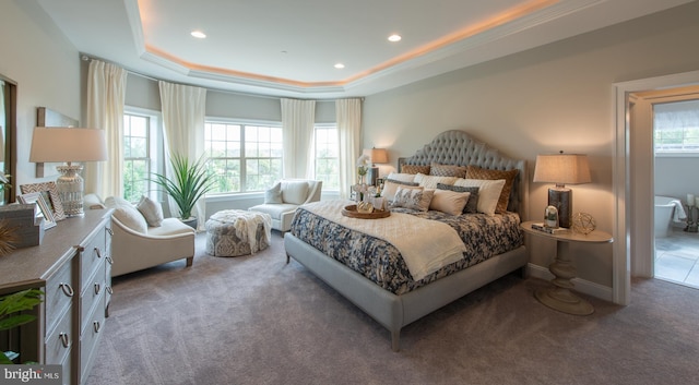 bedroom with a raised ceiling, crown molding, and dark colored carpet