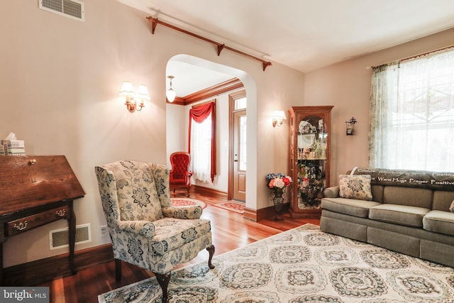 living room featuring ornamental molding and wood-type flooring