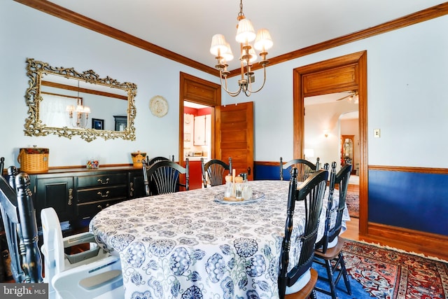 dining space featuring a notable chandelier, crown molding, and hardwood / wood-style flooring