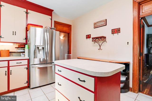 kitchen with light tile floors, white cabinetry, and stainless steel refrigerator with ice dispenser