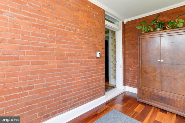 exterior space featuring brick wall, dark hardwood / wood-style floors, and ornamental molding