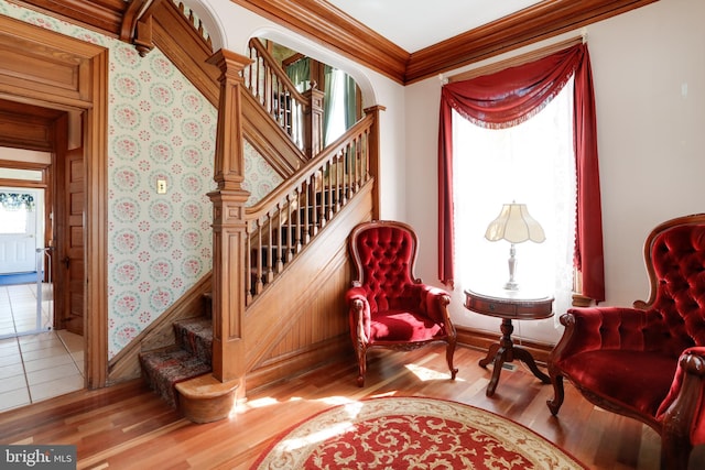 sitting room with ornamental molding and wood-type flooring