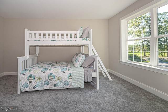 bedroom with dark colored carpet and multiple windows