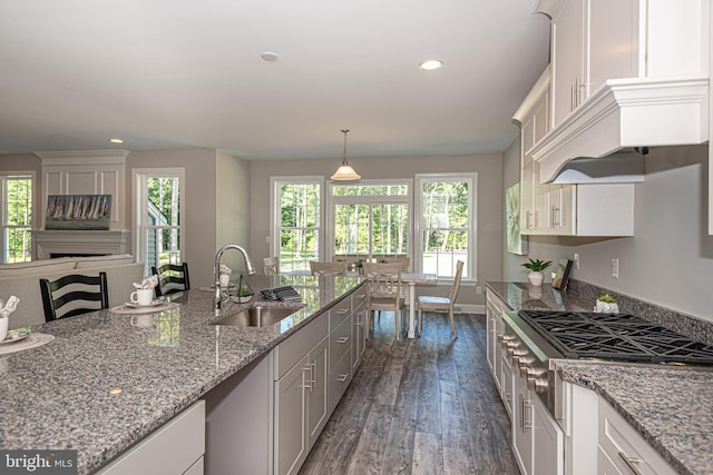 kitchen featuring white cabinets, light stone countertops, and sink