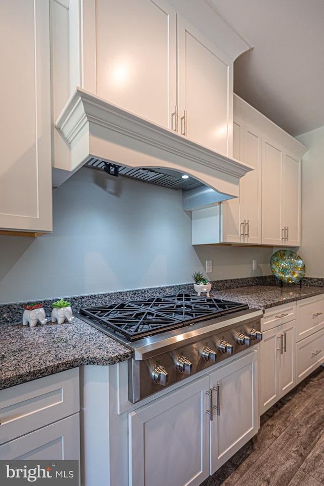 kitchen featuring stainless steel gas cooktop, dark wood-type flooring, white cabinetry, and dark stone counters