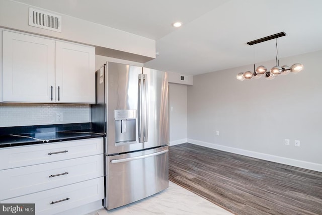 kitchen featuring tasteful backsplash, stainless steel fridge, light hardwood / wood-style floors, decorative light fixtures, and white cabinetry