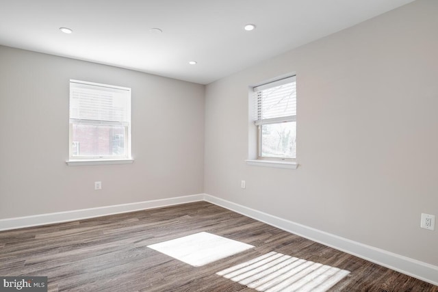 empty room featuring dark hardwood / wood-style flooring and plenty of natural light