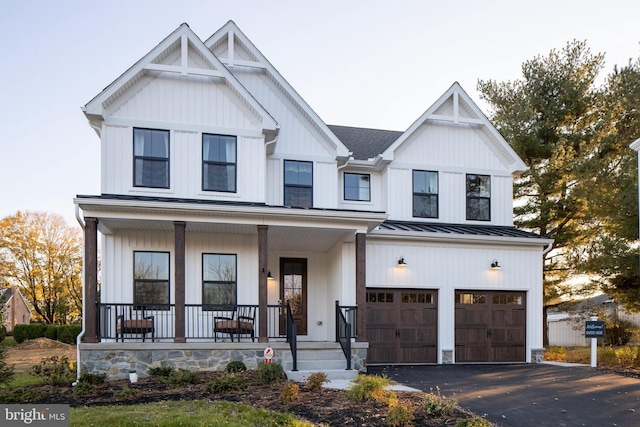 modern farmhouse featuring covered porch and a garage