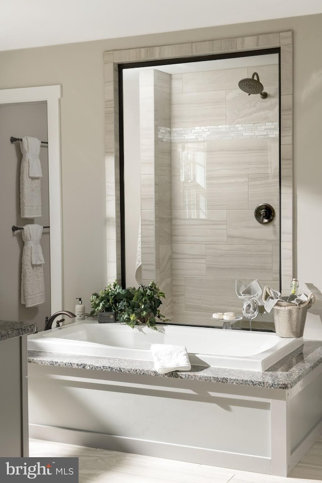 bathroom featuring a tile shower and vanity