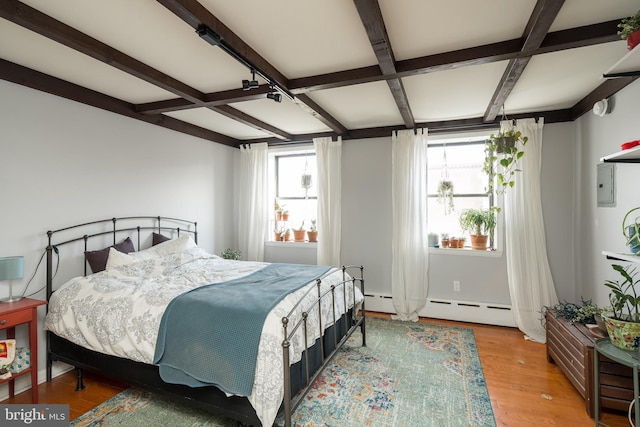 bedroom featuring coffered ceiling, light hardwood / wood-style floors, baseboard heating, and beam ceiling