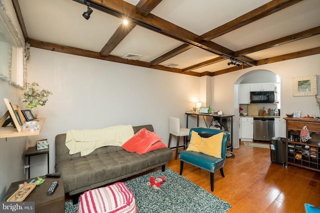 living room featuring beam ceiling and hardwood / wood-style flooring