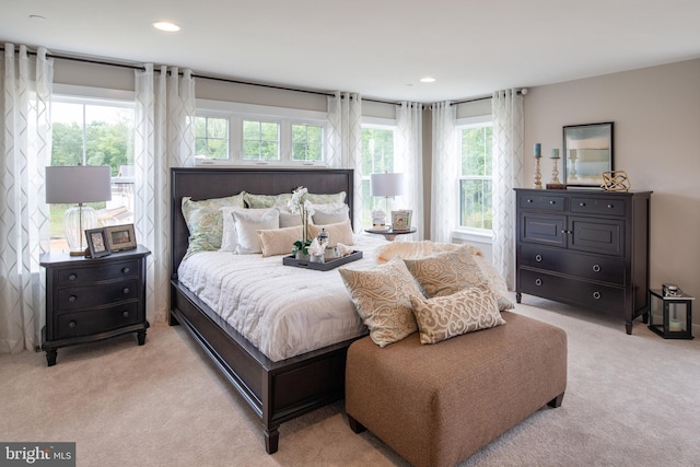 bedroom featuring light carpet and multiple windows