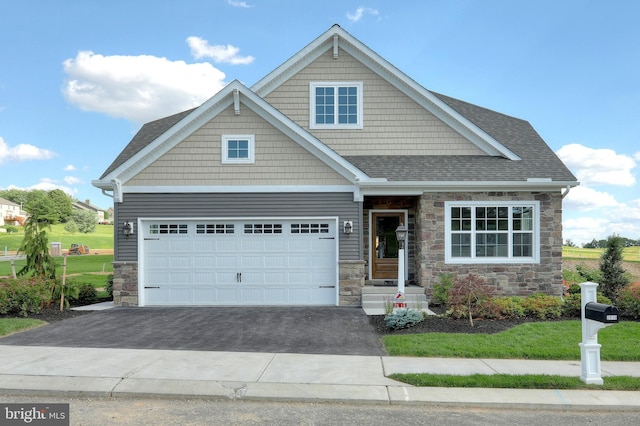 craftsman-style house with stone siding, a shingled roof, and aphalt driveway