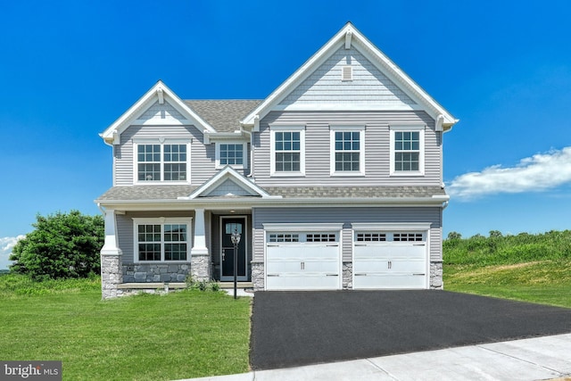 view of front of property featuring a front yard and a garage