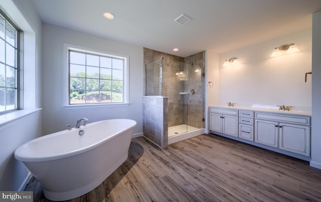 bathroom with shower with separate bathtub, hardwood / wood-style flooring, and double vanity