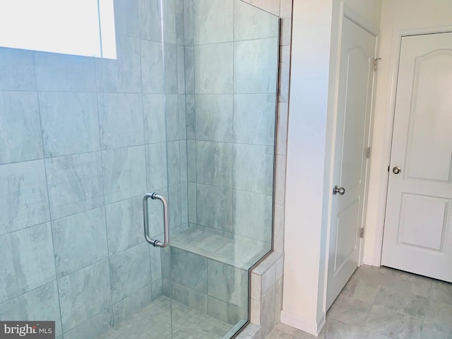 bathroom featuring a shower with shower door and tile floors