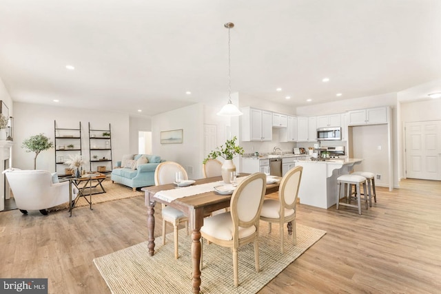 dining space featuring sink and light hardwood / wood-style floors