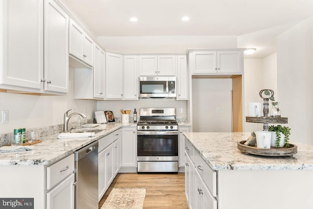 kitchen featuring sink, light wood-type flooring, stainless steel appliances, and white cabinetry