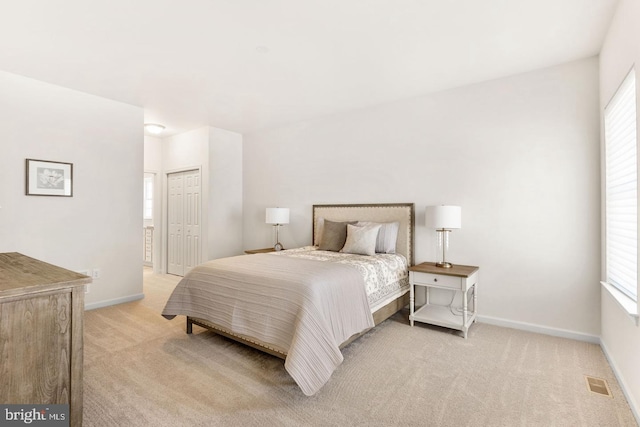 carpeted bedroom featuring a closet and multiple windows