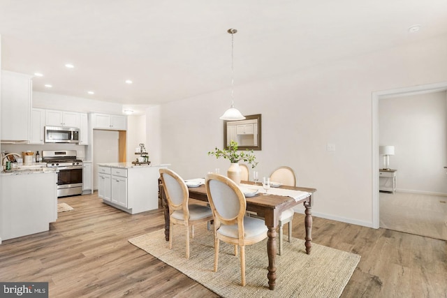 dining space with sink and light hardwood / wood-style flooring