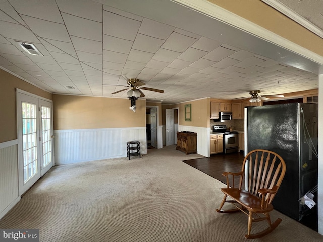 unfurnished room featuring ceiling fan, dark colored carpet, ornamental molding, and french doors