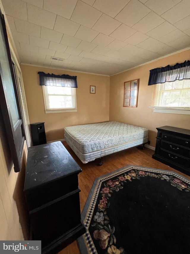 bedroom featuring crown molding and dark hardwood / wood-style flooring