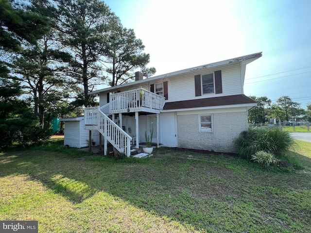 back of property with a deck and a lawn