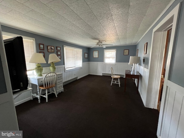 dining space with ceiling fan, dark colored carpet, ornamental molding, and a baseboard radiator