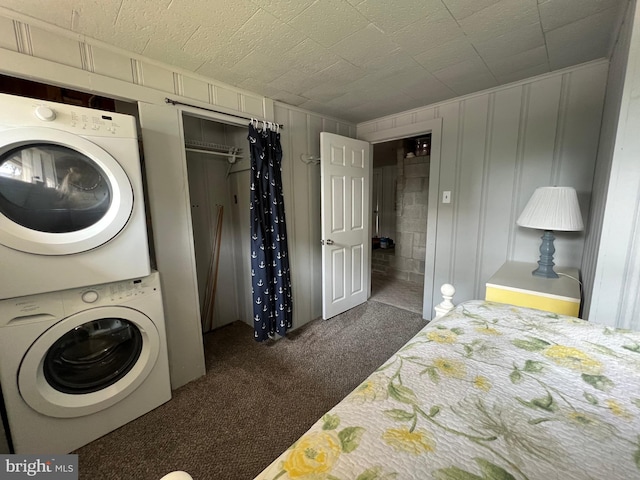 laundry room featuring stacked washer and clothes dryer and dark carpet