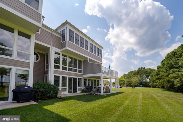 rear view of property with a yard and a patio area