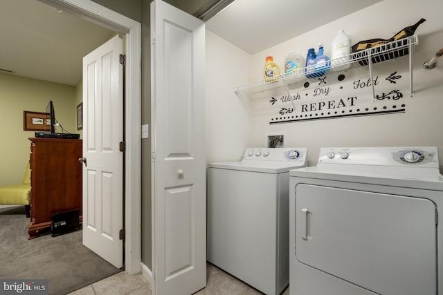 laundry area with light tile floors, washer and clothes dryer, and washer hookup