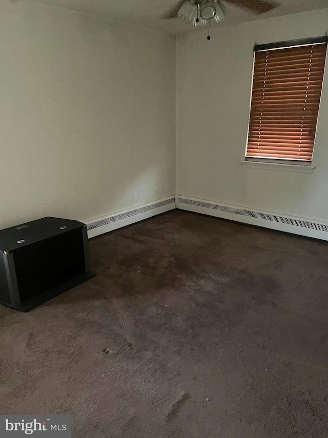 interior space with dark colored carpet, a baseboard radiator, and ceiling fan