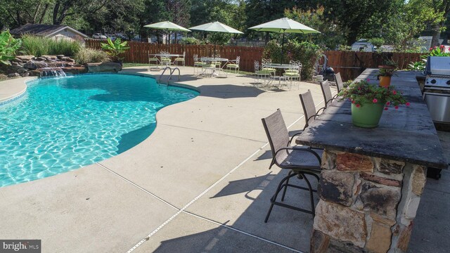 view of pool with a patio area and pool water feature