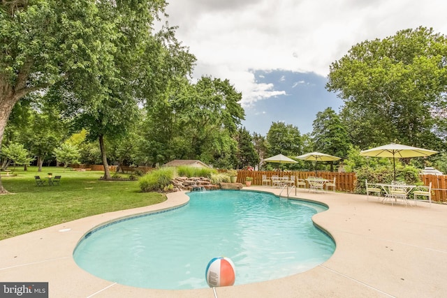 view of swimming pool featuring pool water feature, a yard, and a patio area