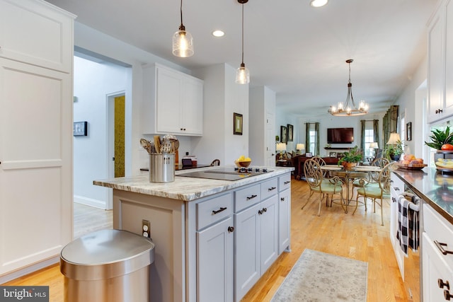 kitchen featuring white cabinets, decorative light fixtures, and an inviting chandelier