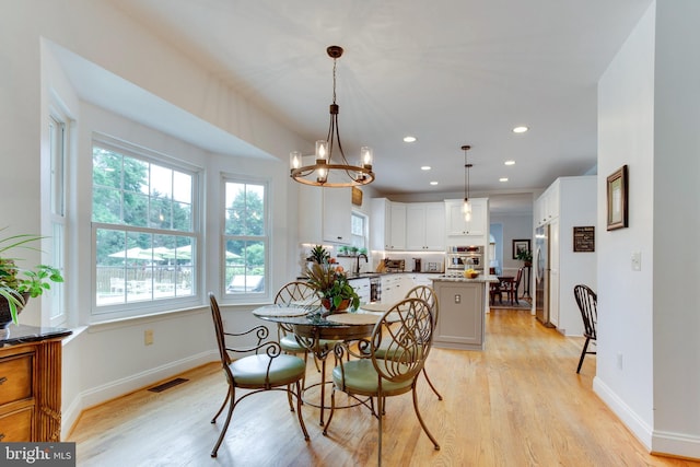 dining room featuring a chandelier, light wood-type flooring, and sink