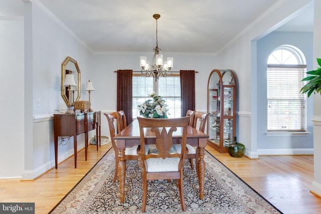 dining room featuring ornamental molding, a notable chandelier, and light wood-type flooring