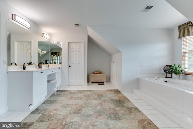 bathroom with tile floors, oversized vanity, and tiled bath