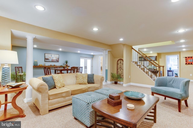 carpeted living room with decorative columns