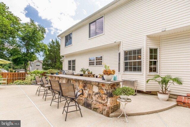 view of patio featuring a bar, a storage shed, and a grill