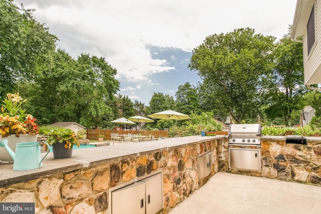 view of terrace with area for grilling and an outdoor kitchen