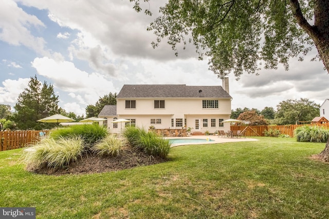 back of property with a lawn, a fenced in pool, and a patio area