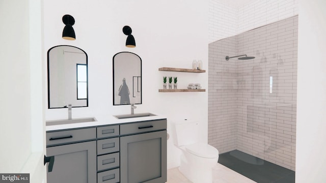 bathroom with toilet, a tile shower, and double sink vanity