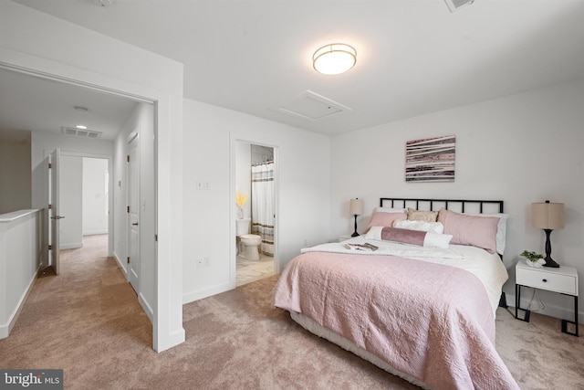 bedroom featuring light colored carpet and ensuite bath