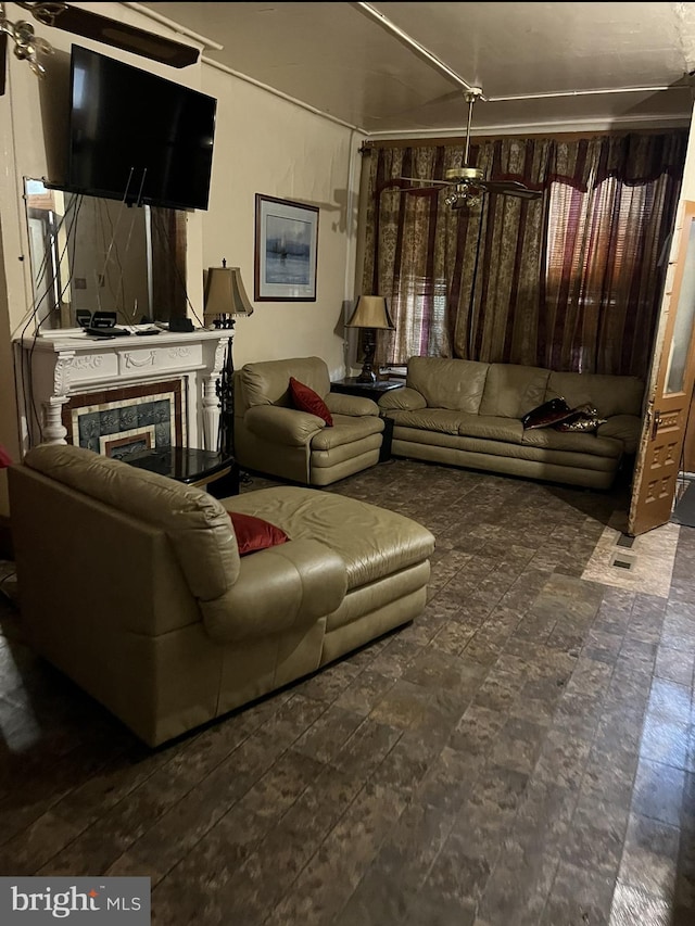 living room with a high end fireplace, dark tile floors, and ceiling fan