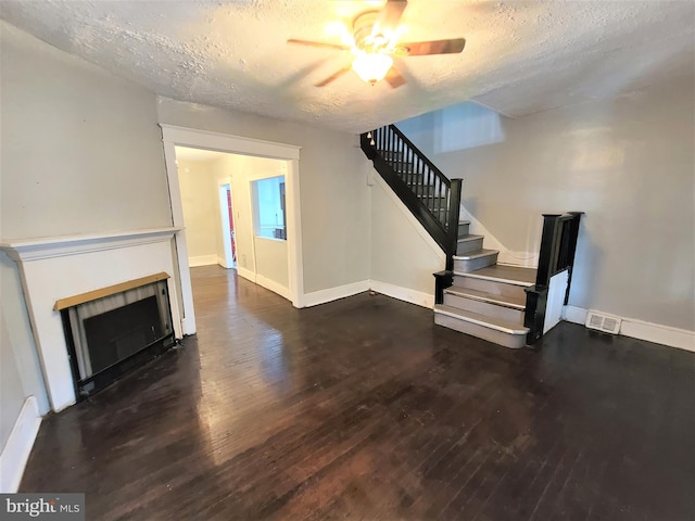 unfurnished living room with dark hardwood / wood-style floors, a textured ceiling, and ceiling fan